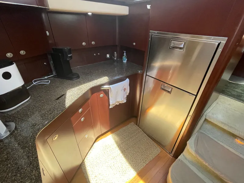 Slide: The Image of The kitchen of a 2007 Sea Ray 40MY with wooden cabinets and stainless steel appliances. - 31
