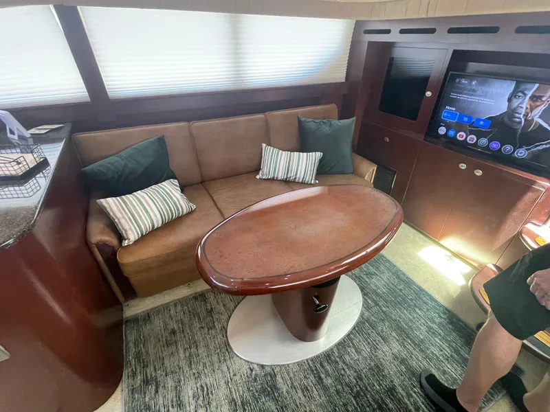 Slide: The Image of Interior of a yacht with a sofa, oval table, and a television. - 33