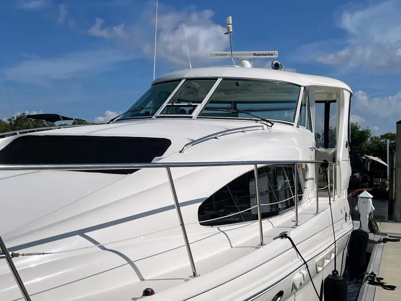 Slide: The Image of A white yacht docked at a marina, surrounded by clear skies and water. - 7