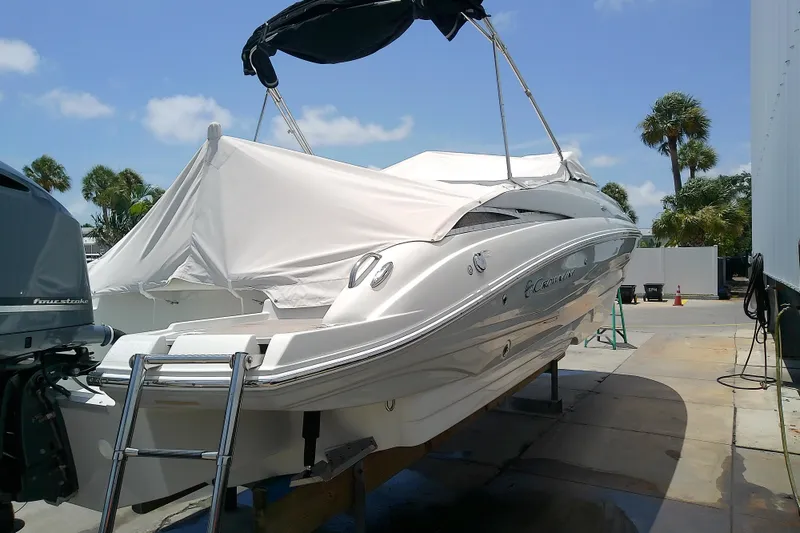 Slide: The Image of 2017 Crownline Eclipse E6 XS boat with cover, parked outdoors on a sunny day. - 17