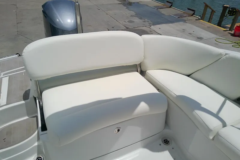 Slide: The Image of 2017 Crownline Eclipse E6 XS boat with white cushioned seating at dockside. - 23