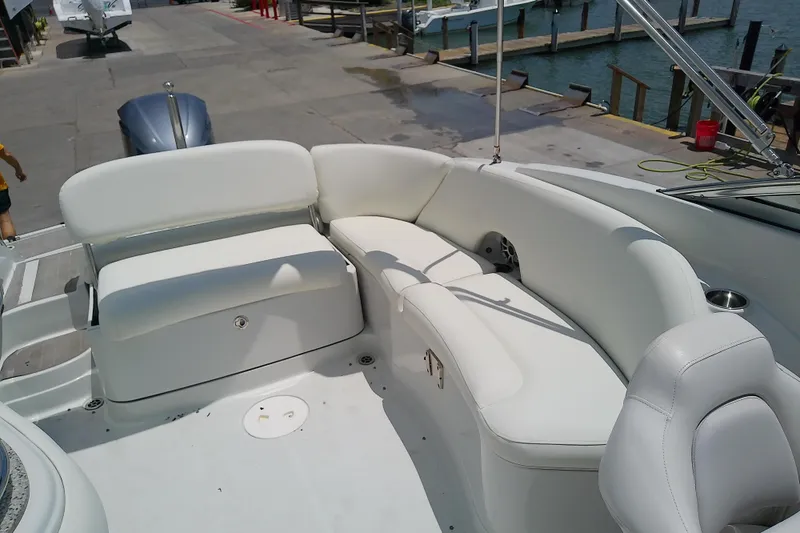 Slide: The Image of 2017 Crownline Eclipse E6 XS boat interior with white seating at a marina. - 24