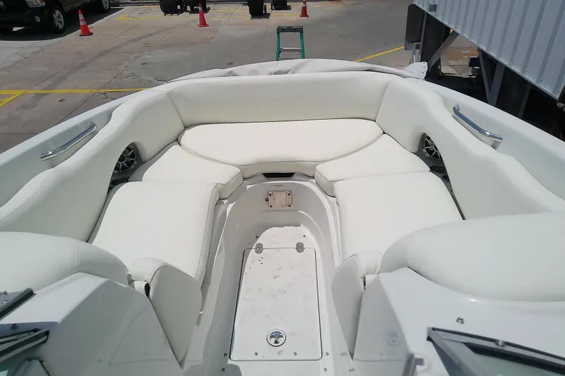 Slide: The Image of 2017 Crownline Eclipse E6 XS boat interior with white seating in a marina setting. - 27