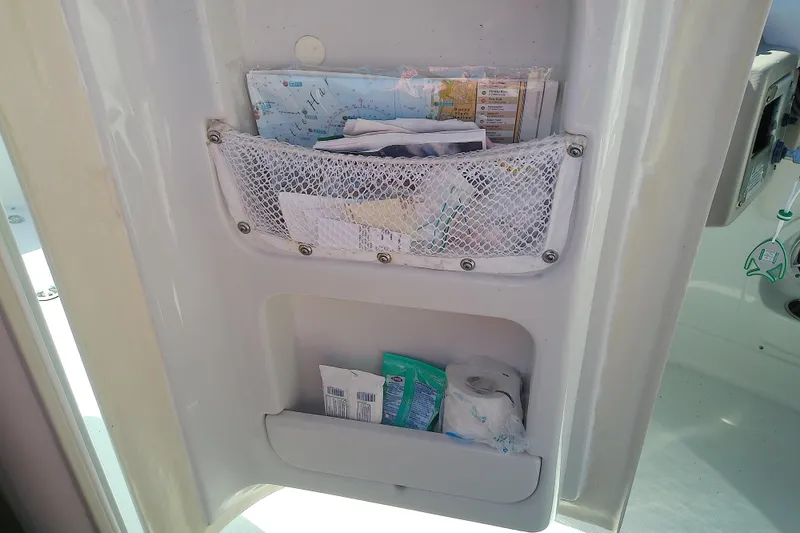 Slide: The Image of Storage compartment on a 2017 Crownline Eclipse E6 XS boat with maps and supplies. - 51
