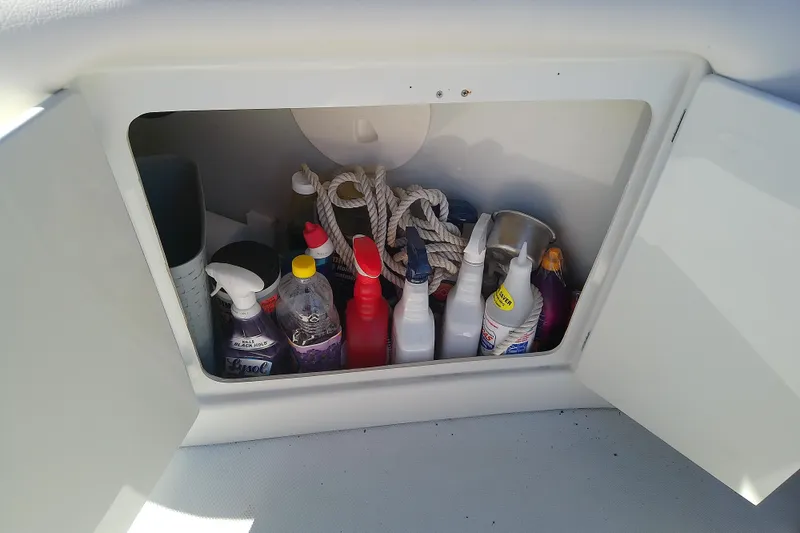 Slide: The Image of Storage compartment in a 2017 Crownline Eclipse E6 XS boat with cleaning supplies and ropes. - 57