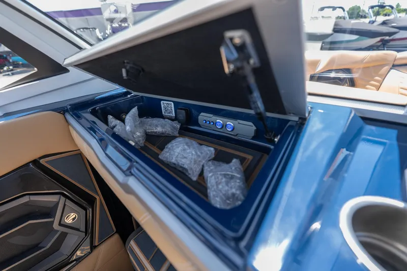 Slide: The Image of Storage compartment in 2026 Tigé Ultré 23ZX boat, featuring ice packs and control buttons. - 17
