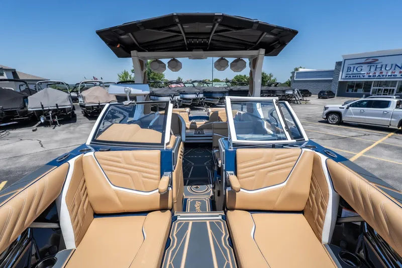 Slide: The Image of 2026 Tigé Ultré 23ZX boat interior with tan seating at a marina. - 22