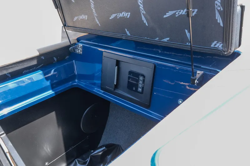 Slide: The Image of 2026 Tigé Ultré 23ZX boat storage compartment with control panel, open lid, and blue interior. - 27
