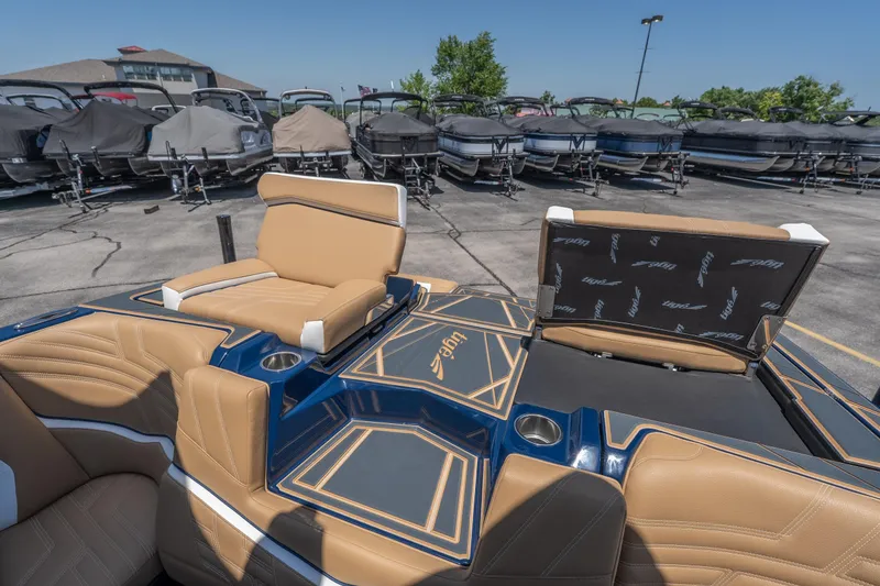 Slide: The Image of 2026 Tigé Ultré 23ZX boat interior with tan seating and cup holders, parked outdoors. - 30