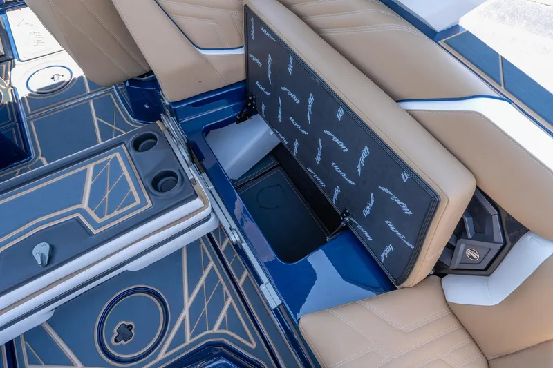 Slide: The Image of 2026 Tigé Ultré 23ZX boat interior with tan seats and blue flooring, featuring storage compartment. - 33