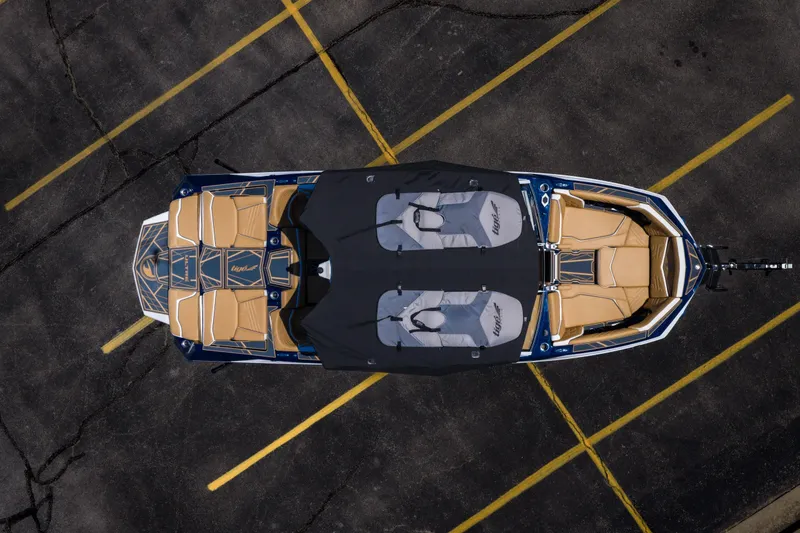 Slide: The Image of 2026 Tigé Ultré 23ZX boat, aerial view, parked on asphalt with tan and black seating. - 40