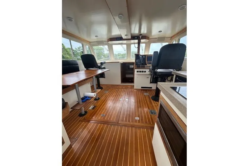 Slide: The Image of Interior of a 2016 Flowers 43 boat with wooden flooring and modern controls. - 10