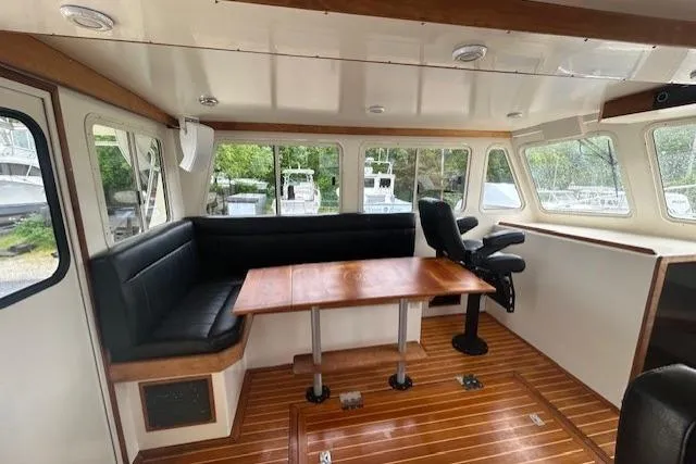 Slide: The Image of Cozy boat interior with wooden flooring, black seating, and large windows, model Flowers 43, 2016. - 12