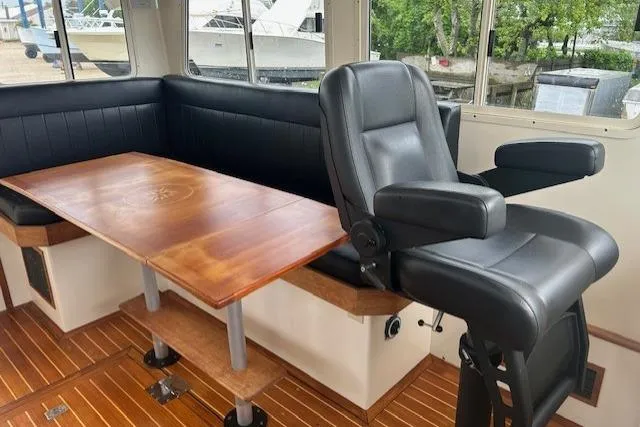 Slide: The Image of Interior of a 2016 Flowers 43 boat with leather seating and wooden table. - 14