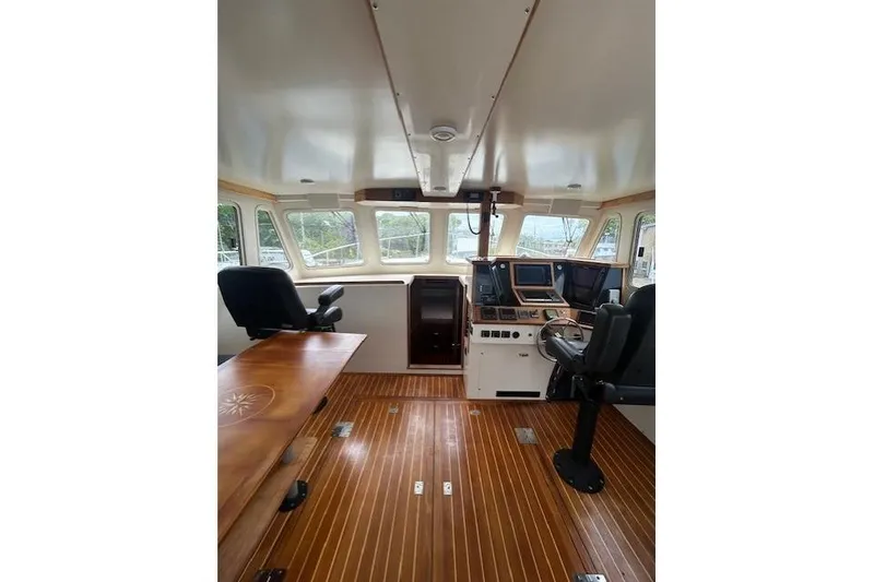 Slide: The Image of Interior of a 2016 Flowers 43 boat, featuring a modern helm and wooden flooring. - 15