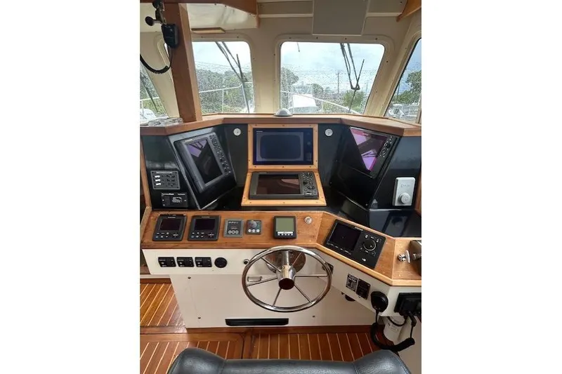 Slide: The Image of Boat cockpit with navigation instruments, steering wheel, and wooden paneling, Flowers 43 model, 2016. - 16