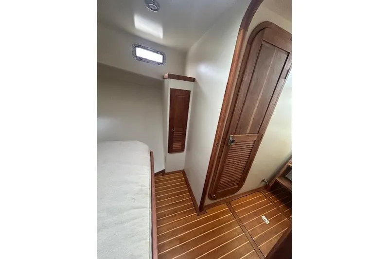 Slide: The Image of Wood-paneled boat cabin interior with bed, window, and storage, Flowers 43 model, 2016. - 21