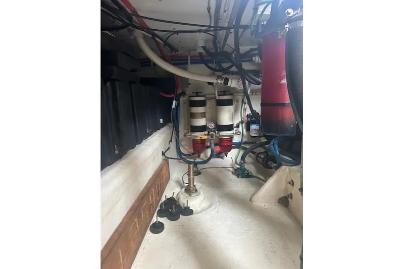 Slide: The Image of Engine room of a 2016 Flowers 43 boat, featuring filters and hoses. - 25