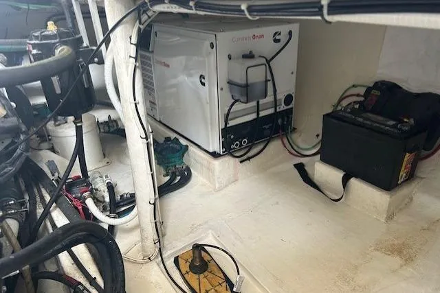 Slide: The Image of Boat engine room with Cummins Onan generator and battery, featuring various cables and components. - 26