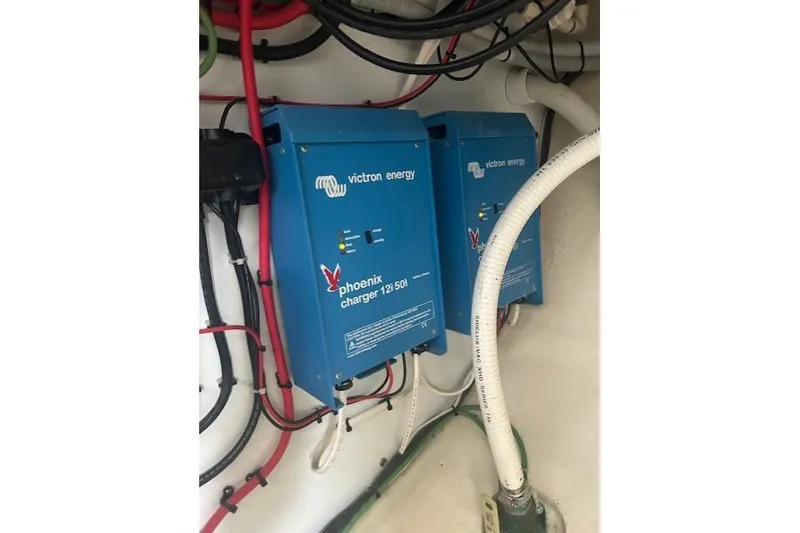 Slide: The Image of Blue Victron Energy Phoenix chargers with wiring, model 12/50, installed on a wall. - 27