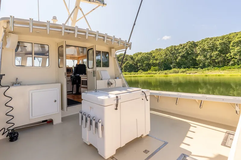 Slide: The Image of Boat deck with fishing equipment, surrounded by lush greenery and calm water. - 10