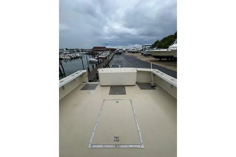 Slide: The Image of Boat deck view at marina with cloudy sky, featuring docked boats and waterfront buildings. - 5