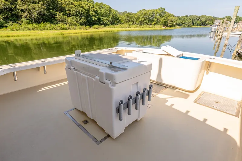 Slide: The Image of Boat deck with white cooler, rod holders, and scenic river view. - 8
