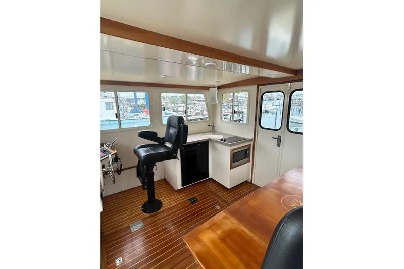 Slide: The Image of Interior of a 2016 Flowers 43 boat with helm, kitchenette, and wooden flooring. - 8