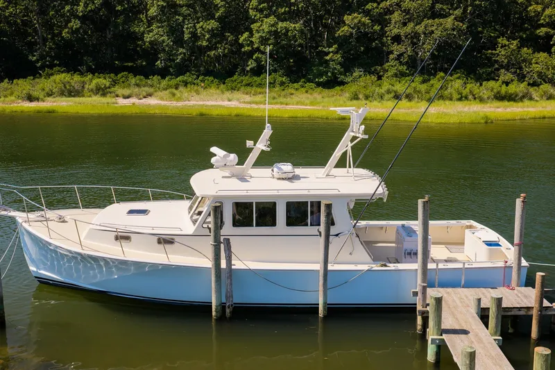 Slide: The Image of A 2016 Flowers 43 boat docked on a serene river with lush greenery. - 3