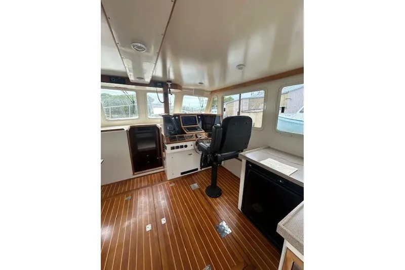Slide: The Image of Boat interior with wooden flooring, modern navigation equipment, and a captain's chair, model Flowers 43. - 9