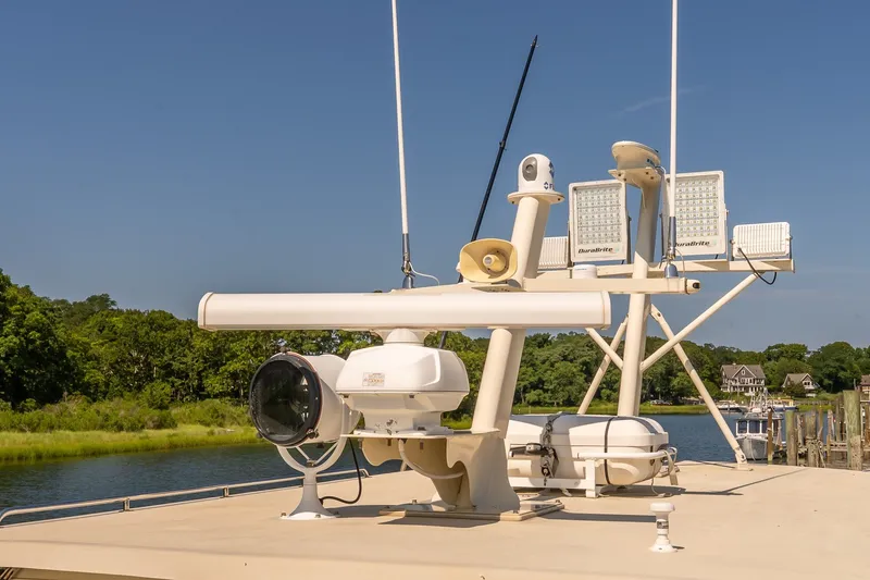 Slide: The Image of Radar and communication equipment on a 2016 Flowers 43 boat, docked by a scenic river. - 23