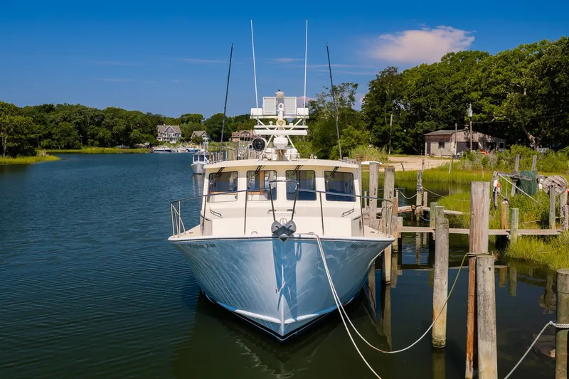 Slide: The Image of A 2016 Flowers 43 boat docked in a serene marina with lush greenery. - 2