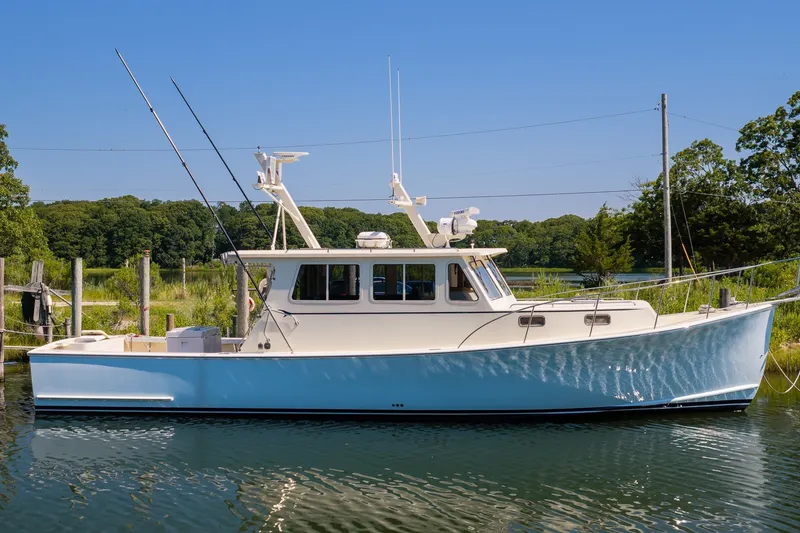 The Image of A 2016 Flowers 43 boat docked on a serene lake under a clear blue sky. - 0