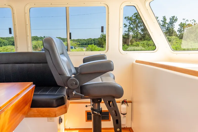 Slide: The Image of Captain's chair in a 2016 Flowers 43 boat interior, with large windows and scenic view. - 27