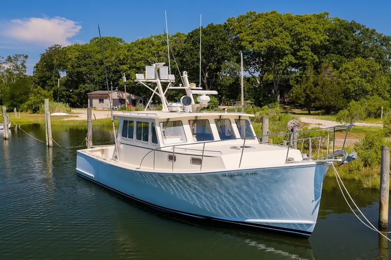 Slide: The Image of White Flowers 43 boat docked in a serene marina, surrounded by lush greenery. - 1