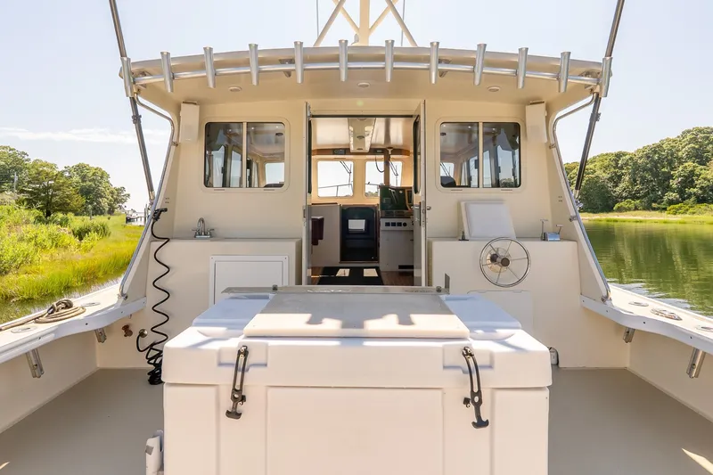 Slide: The Image of Back view of a 2016 Flowers 43 boat docked by lush greenery. - 11
