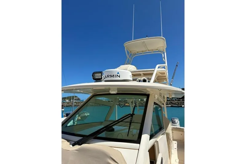 Slide: The Image of 2018 Scout 420 LXF boat with Garmin equipment, docked under clear blue sky. - 12
