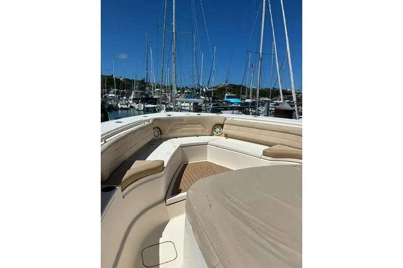 Slide: The Image of 2018 Scout 420 LXF boat interior with beige seating, docked at marina. - 13