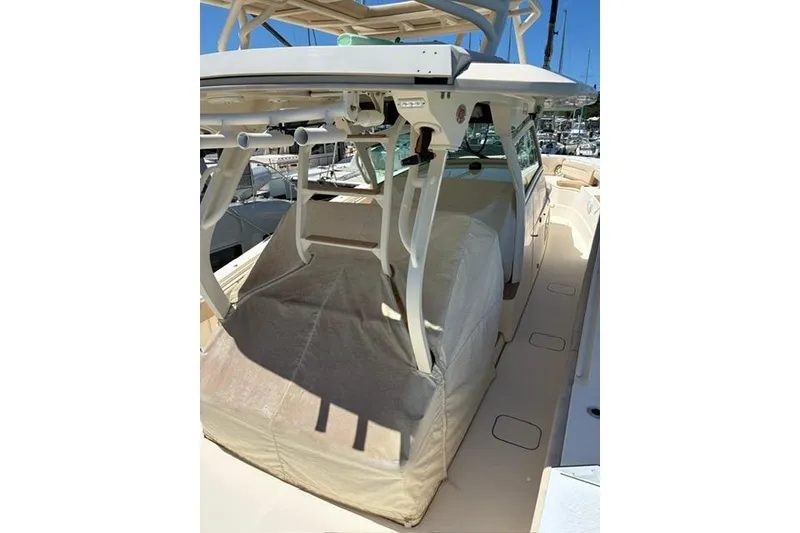 Slide: The Image of 2018 Scout 420 LXF boat with covered seating area, docked at a marina. - 14