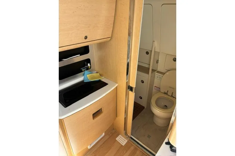 Slide: The Image of Interior of 2018 Scout 420 LXF boat featuring compact bathroom and kitchenette area. - 19
