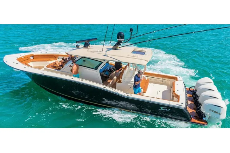 Slide: The Image of Manufacturer Provided Image: 2018 Scout 420 LXF boat cruising on clear blue water. - 2