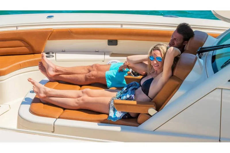 Slide: The Image of Manufacturer Provided Image: Couple relaxing on a 2018 Scout 420 LXF boat in the sun. - 5