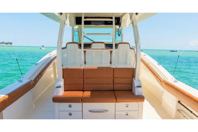 Slide: The Image of Manufacturer Provided Image: 2018 Scout 420 LXF boat interior with tan seating and ocean backdrop. - 8