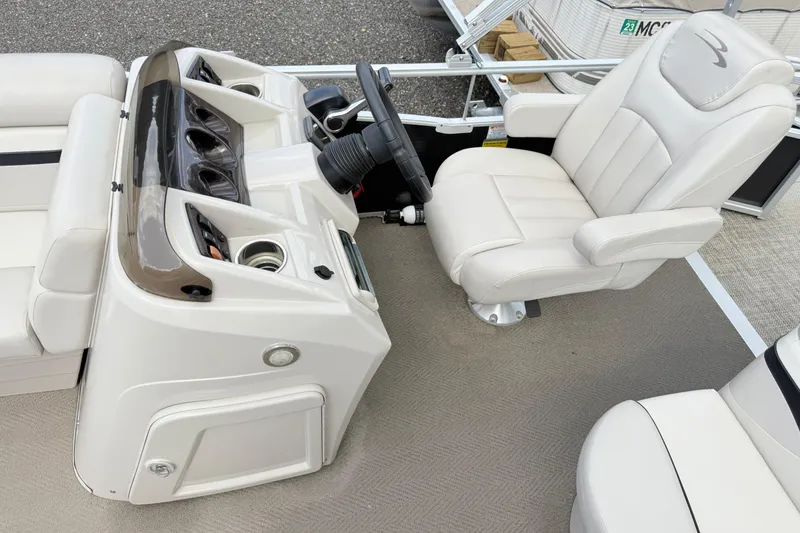 Slide: The Image of Captain's chair and helm of a 2015 Bennington 24SSLX pontoon boat, featuring a sleek dashboard design. - 10