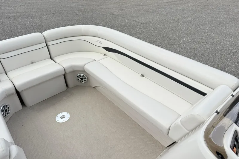 Slide: The Image of 2015 Bennington 24SSLX boat interior with white seating and speaker system. - 4