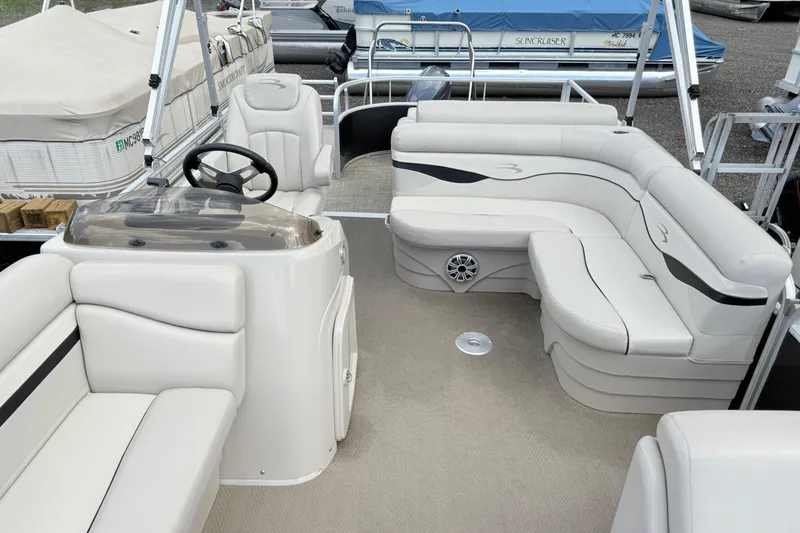 Slide: The Image of 2015 Bennington 24SSLX pontoon boat interior with plush seating and steering console. - 7