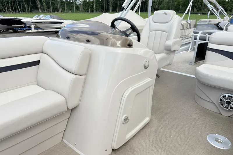 Slide: The Image of 2015 Bennington 24SSLX pontoon boat interior with plush seating and steering console. - 8