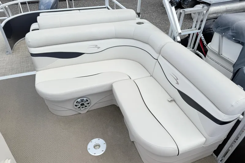 Slide: The Image of 2015 Bennington 24SSLX pontoon boat with white cushioned seating and speaker detail. - 9