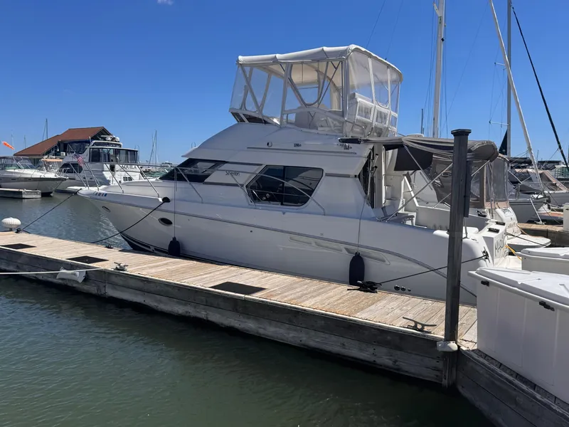 The Image of A 1998 Silverton 351 Sedan docked at a wooden pier in a marina. - 0