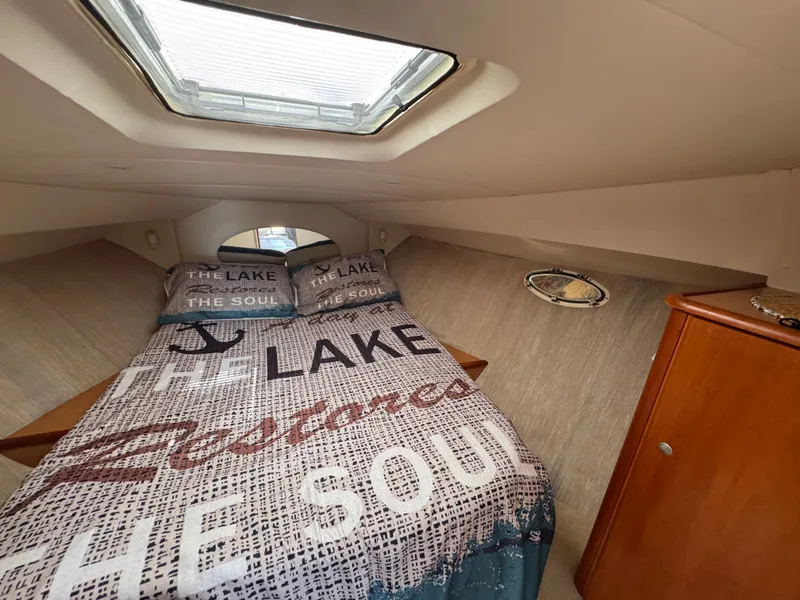 Slide: The Image of Interior of a 1998 Silverton 351 Sedan with a cozy bed and skylight. - 17
